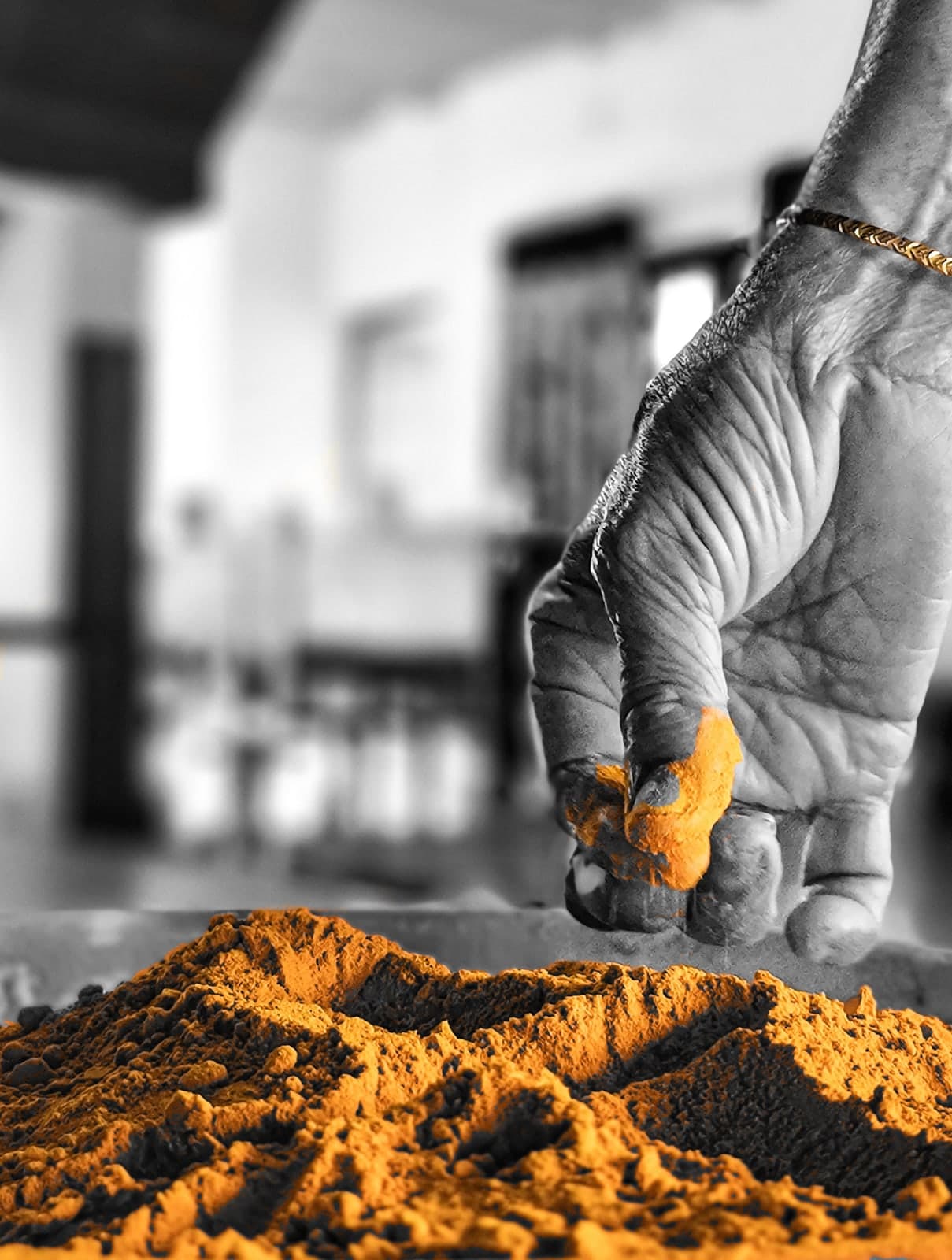 A grandmother's hands working freshly ground turmeric in the family home
